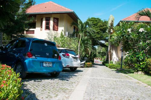 two cars parked in front of a house at Samui Green Life in Bophut 
