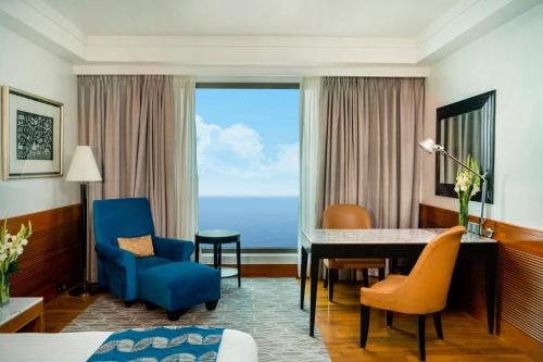 a hotel room with a desk and chairs and a table at InterContinental Marine Drive Mumbai by IHG in Mumbai