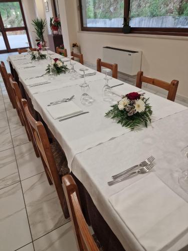 a long table with white table cloth and flowers on it at Agriturismo Pavoni in Castelliri