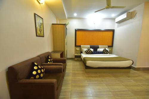 a hotel room with a bed and a couch at Hotel Royal Highness in Tinsukia