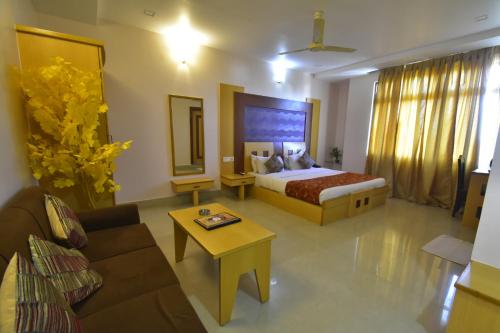 a hotel room with a bed and a couch at Hotel Royal Highness in Tinsukia