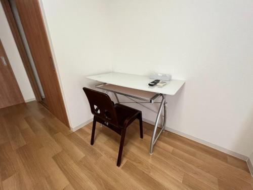 een wit bureau met een stoel naast een muur bij Wakatake Building Room 453 - Vacation STAY 53947v in Oita