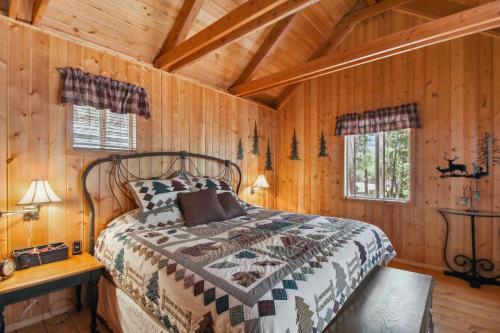 ein Schlafzimmer mit einem Bett in einer Holzhütte in der Unterkunft Tranquil Forest Lakes Retreat Yard, Deck and Gazebo in Forest Lakes Estates