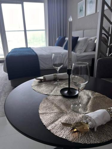 un tavolo con due bicchieri di vino e una candela sopra di Nice studio with panoramic view of the Canal! a Dubai