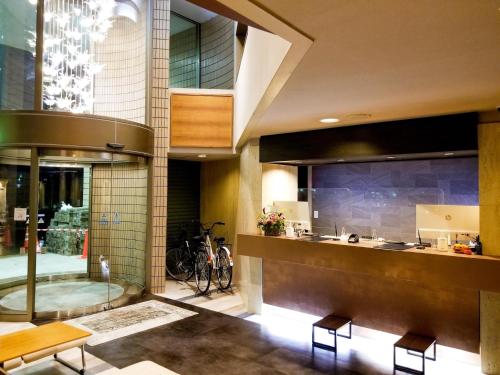 a kitchen with a counter and chairs in a building at Hotel AreaOne Minamisoma - Vacation STAY 56244v in Minamisouma