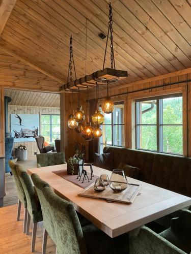 a dining room with a large wooden table and chairs at Hjemmekoselig hytte på Rauland in Rauland