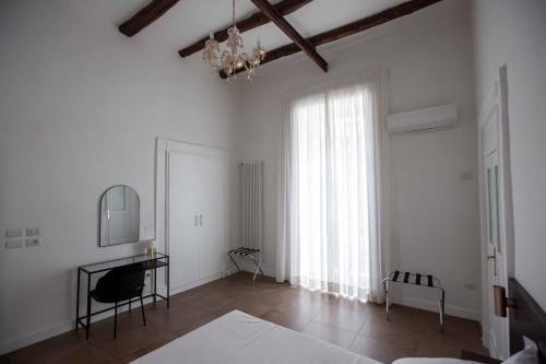 Camera bianca con tavolo e finestra di Domus Delia Luxury Apartment a Napoli