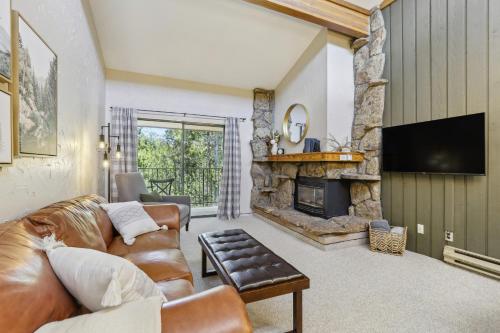 a living room with a couch and a fireplace at Cozy Winter Park Condo Bike, Ski, and Hike! in Winter Park