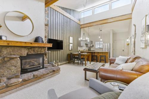 a living room with a couch and a fireplace at Cozy Winter Park Condo Bike, Ski, and Hike! in Winter Park