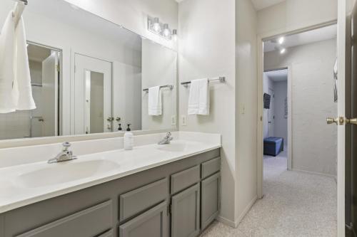 a bathroom with two sinks and a large mirror at Cozy Winter Park Condo Bike, Ski, and Hike! in Winter Park