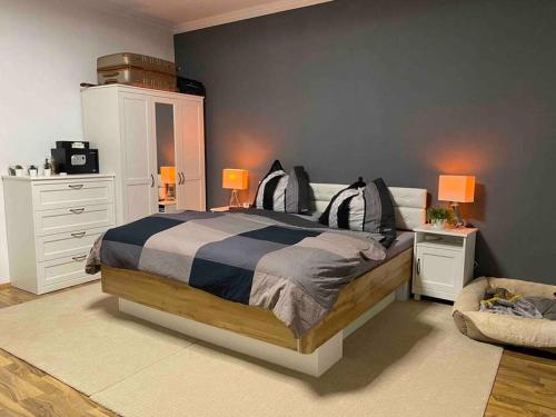 Modern Apartment near RedBull Circuit في زيلتويج: غرفة نوم مع سرير مع مواقف ليلتين ومصباحين