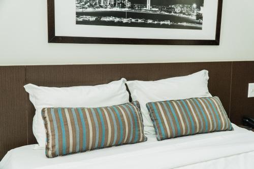 a bed with two pillows on top of it at Bonaparte Excelente Apartamento #503 in Brasilia
