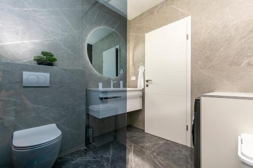 ein Badezimmer mit einem WC, einem Waschbecken und einem Spiegel in der Unterkunft New Apartment White Angel in Duće