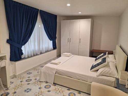 卡帕喬－帕埃斯圖姆的住宿－Camera Vista Capri，一间卧室配有一张带蓝色窗帘的大床