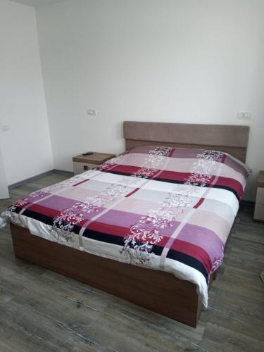 - une chambre avec un lit et une couette rouge et blanche dans l'établissement New Apartment, à Petroşani