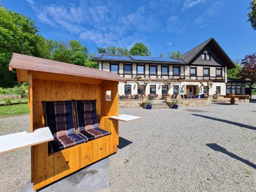 a large building with a bench in front of it at Hotel Waldquelle - Baumhaushotel Aerzen in Aerzen