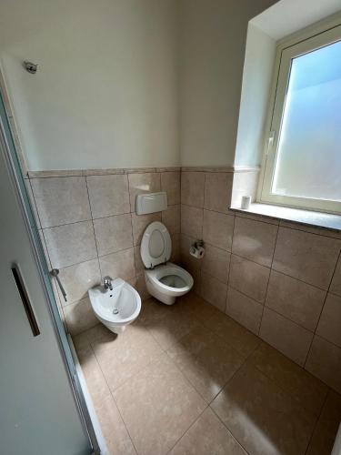 a bathroom with a toilet and a sink at A 2 passi dal mare II - grazioso trilocale a Locri in Locri