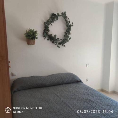 a bedroom with a bed and a wreath on the wall at Apartamento a 9 min centro in Fuengirola