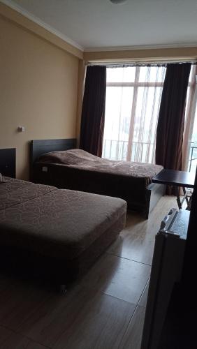 a hotel room with two beds and a window at Apartment Zhemchuzhina Ureki-3 СТУДИО in Ureki