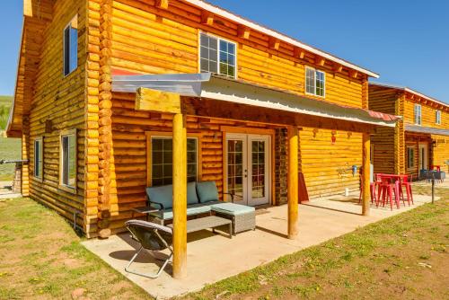 a log cabin with a bench on a patio at Mountain Cabin in Wyoming Range Scenic and Remote! in Kemmerer