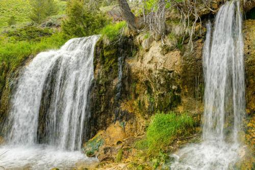 a waterfall on the side of a rocky cliff at Mountain Cabin in Wyoming Range Scenic and Remote! in Kemmerer