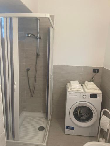 a bathroom with a shower and a washing machine at Greta's Home a 2 minuti dal lago in Arona