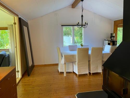 a kitchen and dining room with a table and chairs at Sjönära stuga in Norrtälje