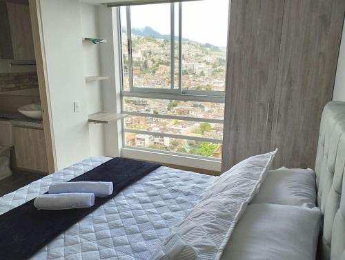 łóżko w pokoju z dużym oknem w obiekcie Luxury la Candelaria Bogota w mieście Bogota