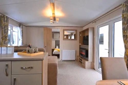 a kitchen and living room with a couch and a table at Rohannah static Caravan Fantastic Family and Friends Holiday in East Mersea