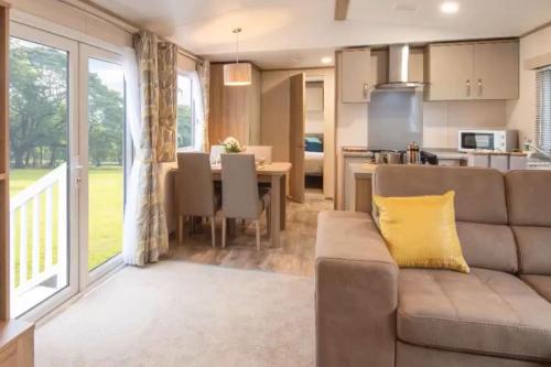 a living room with a couch and a table at Rohannah Luxe Coastal Escape, Cooper Beach East Mersea in East Mersea