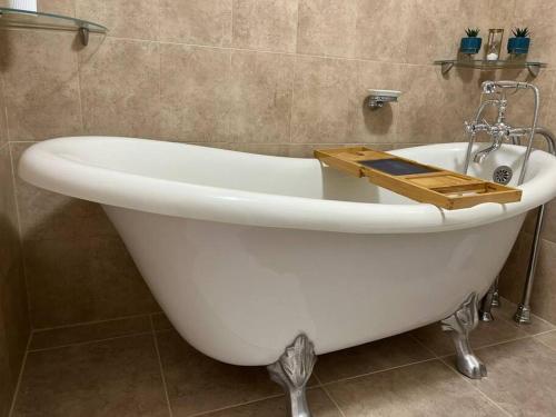 a white bath tub with a wooden tray on top of it at The Diver's Inn Grand Cayman in George Town