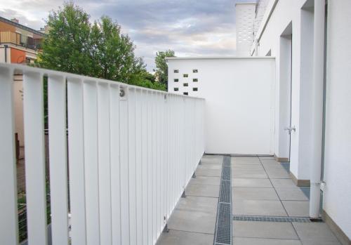 a white fence with a walkway at Flat2go modern apartments - Harmony of city and nature in Vienna