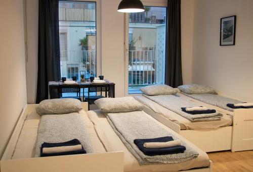 Habitación con 4 camas y toallas. en Flat2go modern apartments - Harmony of city and nature, en Viena
