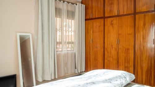 1 dormitorio con cama y ventana grande en The Terrace Villa en Kampala