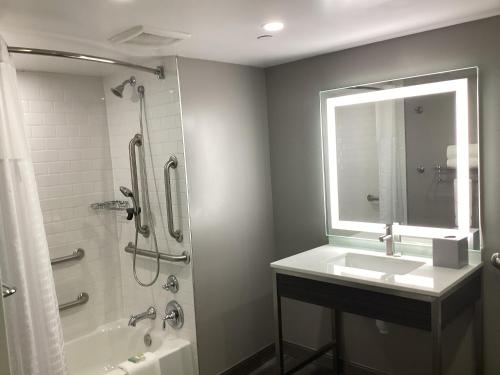 a bathroom with a sink and a shower with a mirror at Days-Inn by Wyndham Baltimore Northwest in Baltimore