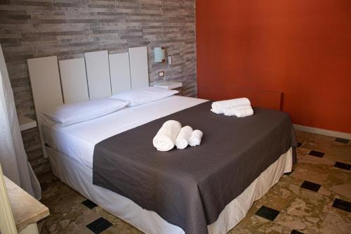 a bedroom with a bed with two white towels on it at Mirage Place B&B in Catania