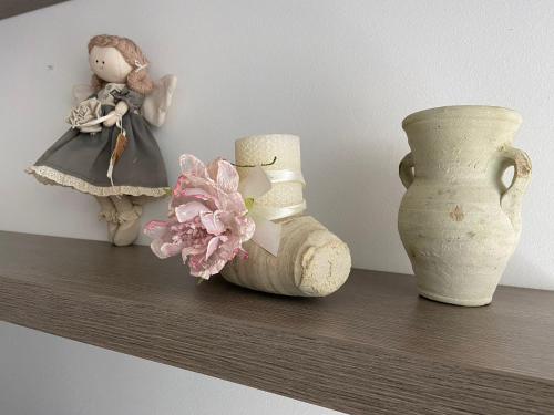 three vases and a doll sitting on a shelf at Appartamento Raf&Ste in Campomarino