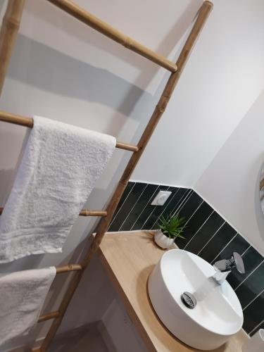 La salle de bains est pourvue d'un lavabo blanc et d'une serviette. dans l'établissement T2 cosy - centre ville, à Marseille