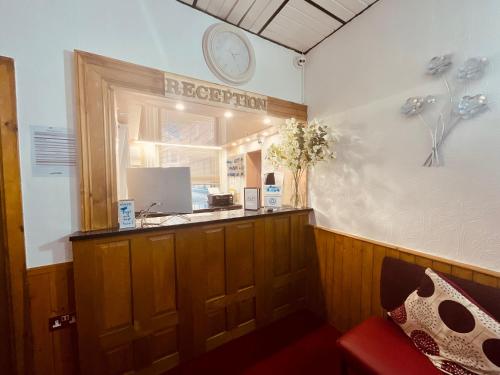 a reception counter in a room with a red couch at The Danescourt in Blackpool