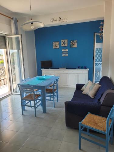 ein Wohnzimmer mit einem blauen Tisch und einem Sofa in der Unterkunft Bilocale Lungomare Carini in Carini