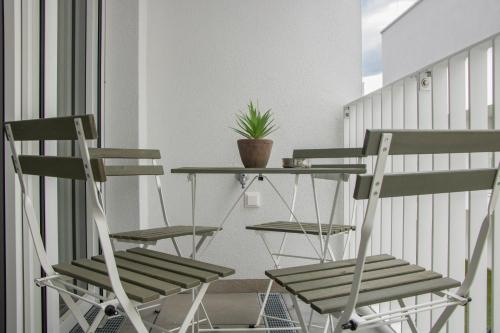 two chairs and a table on a balcony with a plant at Flat2go modern apartments - Harmony of city and nature in Vienna