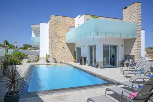 a villa with a swimming pool in front of a building at Villa Luz 37 - Jacuzzi Terrace & Swimming Pool in Albufeira