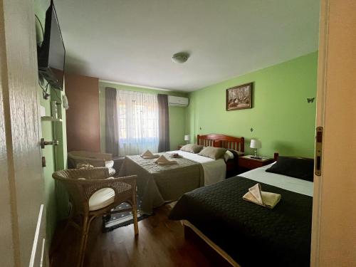 una camera d'albergo con due letti e una sedia di Apartman Simona a Vrdnik