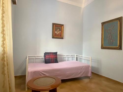 a bedroom with a bed with a pink blanket and a table at Tiffany's 5' min from airport in Spata