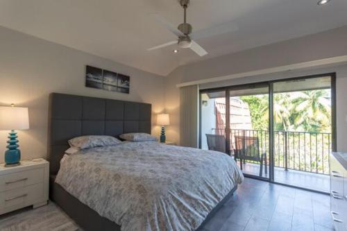 ein Schlafzimmer mit einem großen Bett und einem Balkon in der Unterkunft Beach Living at Villas Pappagallo BLES in West Bay