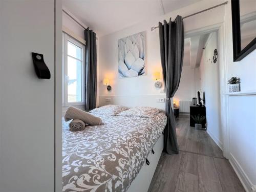 a bedroom with a bed and a large window at Le Cyrano, Deauville - App. T2 proche de la mer in Deauville