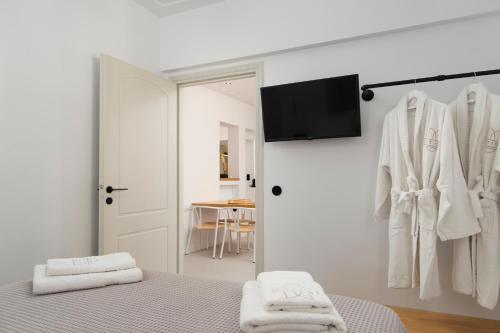 Habitación blanca con cama y armario en ISTION ANDROS LUXURY SUITES en Ándros