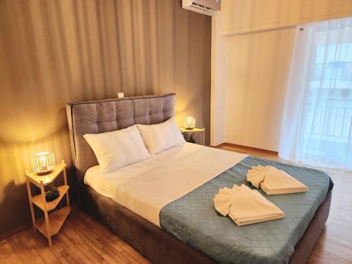 een slaapkamer met een bed met twee handdoeken erop bij Acropolis Memories greendom in Athene