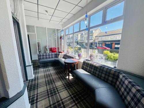 a room with a couch and a table and windows at The Danescourt in Blackpool