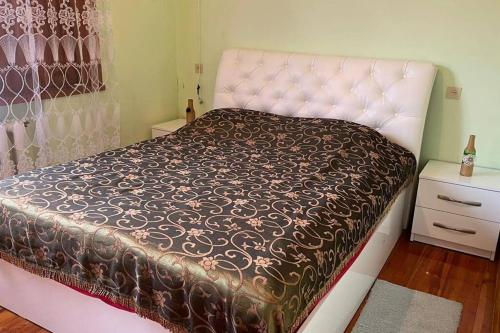 - une chambre avec un lit et une couette marron et blanche dans l'établissement House in beautiful Kutaisi, à Koutaïssi